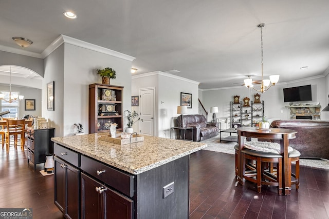 kitchen with dark wood-type flooring, a kitchen island, a notable chandelier, and pendant lighting