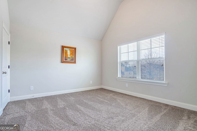 carpeted empty room featuring lofted ceiling