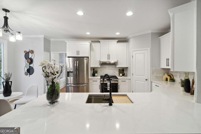 kitchen featuring crown molding, decorative light fixtures, white cabinets, stainless steel appliances, and backsplash