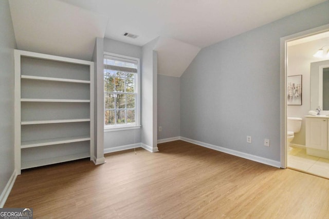 bonus room featuring vaulted ceiling and light hardwood / wood-style flooring