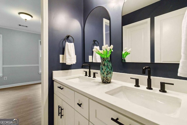 bathroom featuring crown molding, vanity, and hardwood / wood-style floors