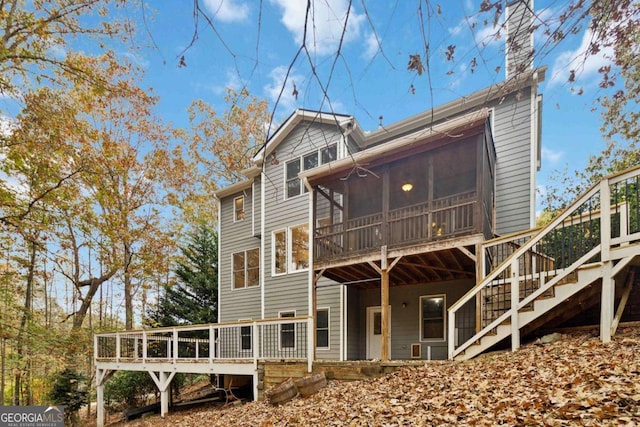 back of property with a wooden deck and a sunroom