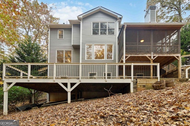 back of property featuring a sunroom and a deck