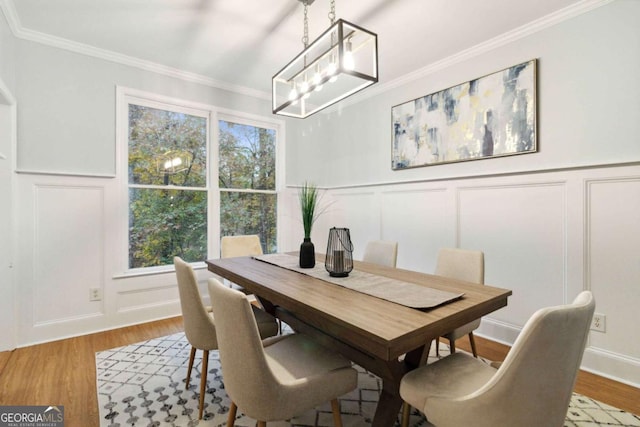 dining room featuring a notable chandelier, crown molding, and light wood-type flooring