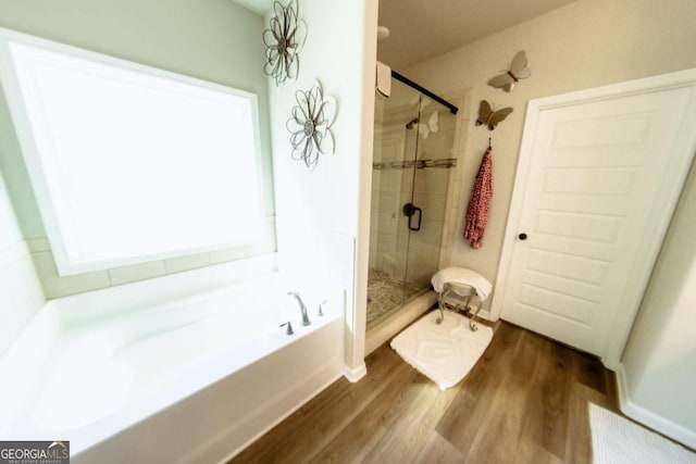 bathroom featuring shower with separate bathtub and hardwood / wood-style floors