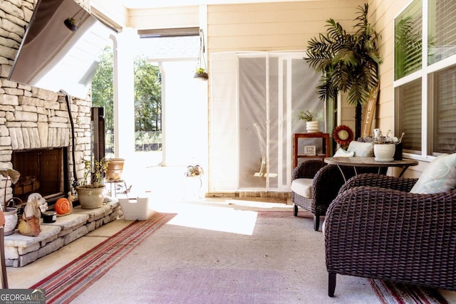 living area featuring floor to ceiling windows, carpet, and an outdoor stone fireplace