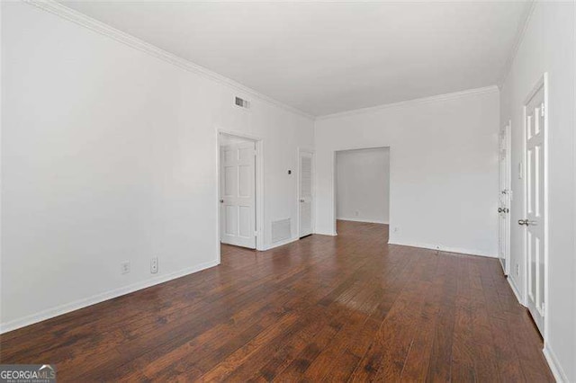 empty room featuring ornamental molding and dark hardwood / wood-style floors