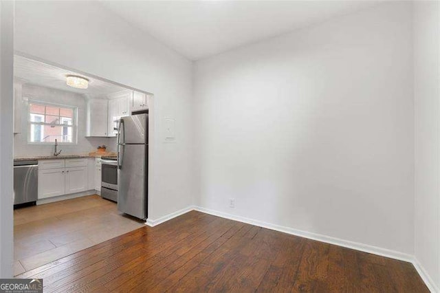 kitchen featuring white cabinetry, appliances with stainless steel finishes, and hardwood / wood-style flooring