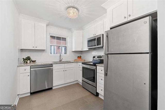 kitchen with stainless steel appliances, sink, white cabinets, and backsplash