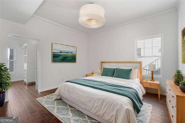 bedroom with crown molding and dark wood-type flooring