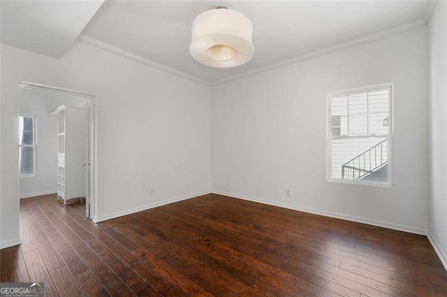 empty room featuring ornamental molding and dark hardwood / wood-style floors