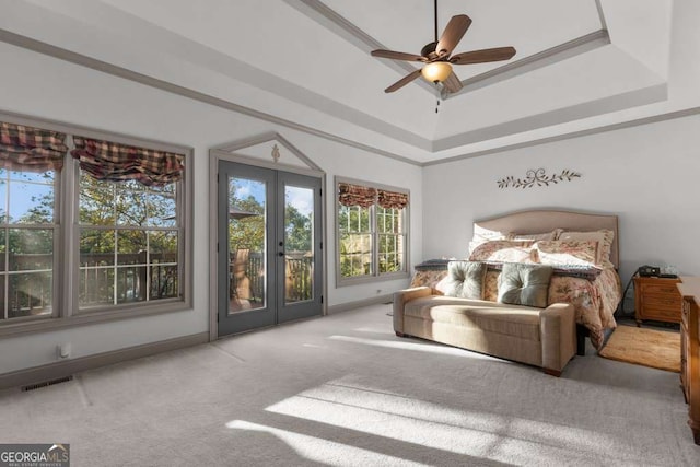 carpeted bedroom with access to exterior, french doors, and a raised ceiling