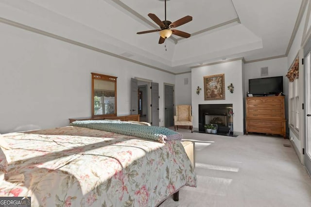 bedroom with ceiling fan, ornamental molding, a raised ceiling, and light carpet