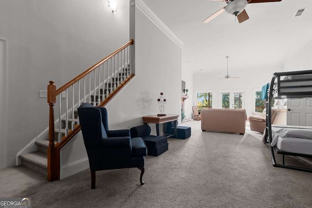 living room with crown molding, ceiling fan, carpet flooring, and a high ceiling