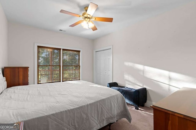 carpeted bedroom featuring ceiling fan and a closet