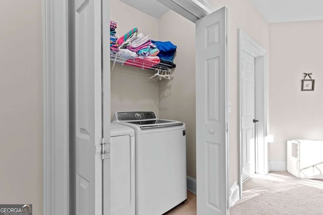 washroom with separate washer and dryer and light colored carpet