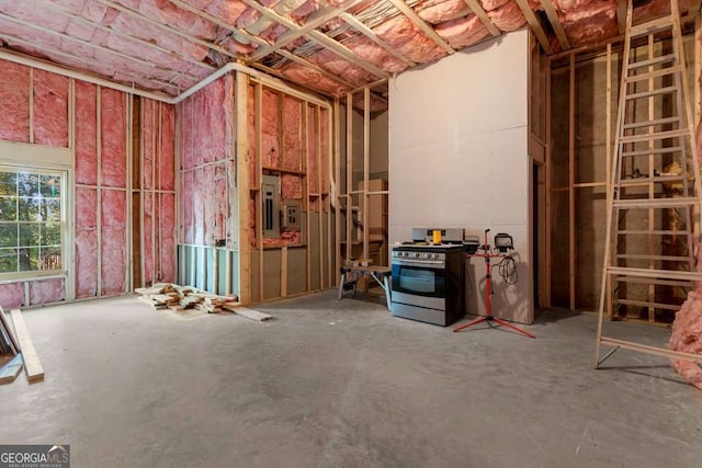 misc room with concrete flooring and electric panel