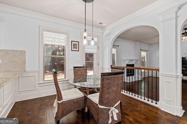 dining space featuring crown molding, a premium fireplace, and dark hardwood / wood-style flooring