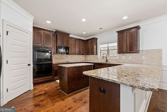 kitchen featuring sink, dark hardwood / wood-style flooring, ornamental molding, a center island, and black appliances