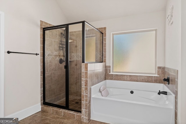 bathroom featuring vaulted ceiling, separate shower and tub, and tile patterned floors