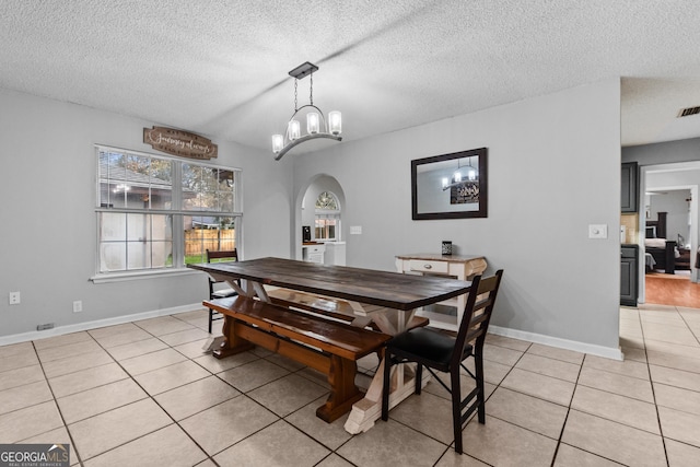 dining space with light tile patterned floors and a textured ceiling