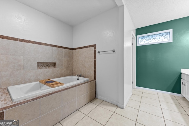 bathroom featuring a relaxing tiled tub, tile patterned floors, vanity, and a textured ceiling