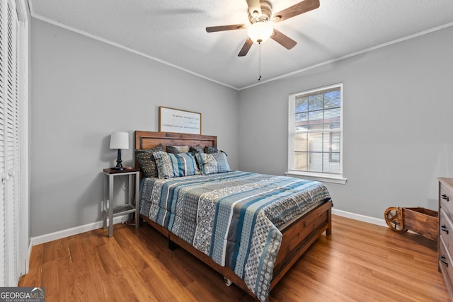 bedroom featuring crown molding, a textured ceiling, and light wood-type flooring