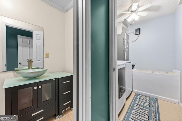 bathroom with washing machine and clothes dryer, crown molding, vanity, ceiling fan, and tile patterned flooring