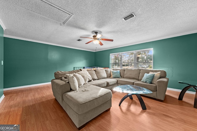 living room with crown molding, wood-type flooring, and a textured ceiling