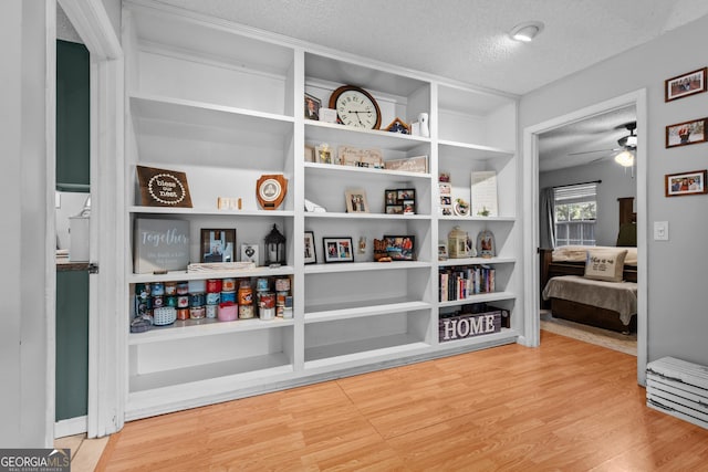 interior space with hardwood / wood-style floors, a textured ceiling, and ceiling fan