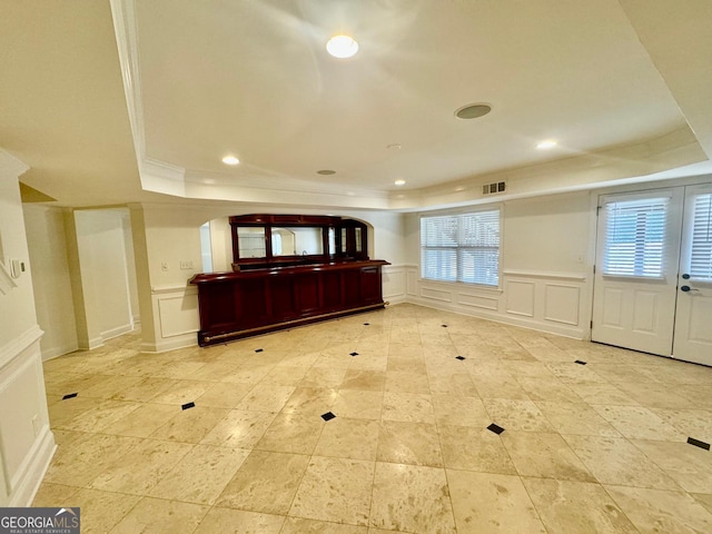 entrance foyer featuring a raised ceiling and ornamental molding