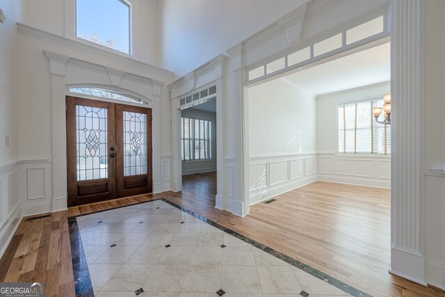 unfurnished living room featuring a notable chandelier and light hardwood / wood-style flooring