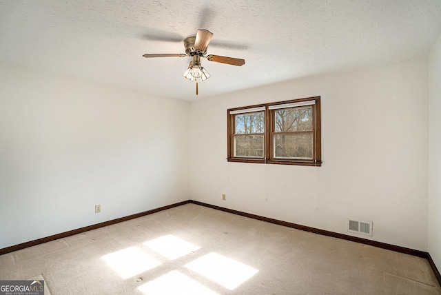 unfurnished room featuring ceiling fan, carpet floors, and a textured ceiling