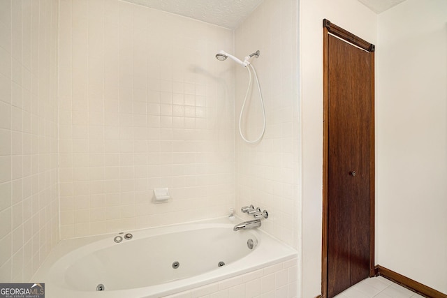 bathroom with tile patterned floors, tiled shower / bath combo, and a textured ceiling