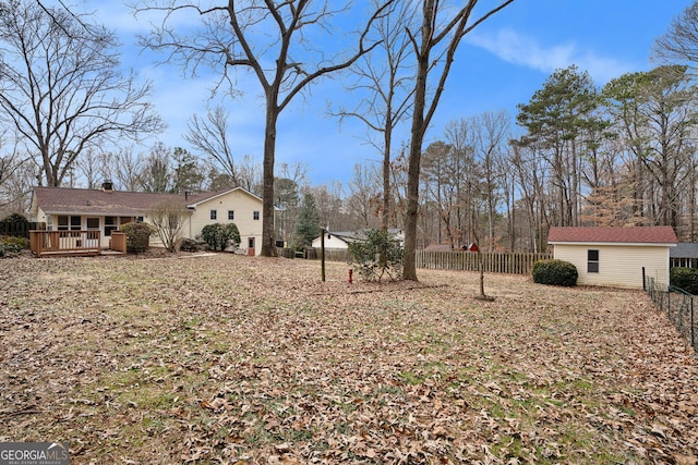 view of yard featuring a wooden deck and an outdoor structure