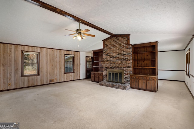 unfurnished living room featuring a brick fireplace, light colored carpet, and a textured ceiling