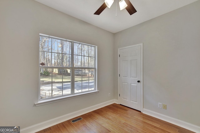 empty room with ceiling fan and light hardwood / wood-style floors