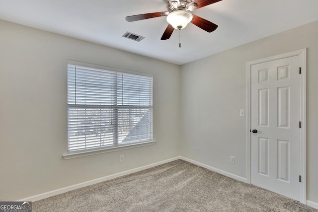 spare room with ceiling fan and carpet