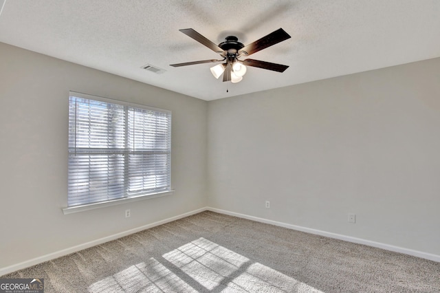 carpeted empty room featuring ceiling fan and a textured ceiling