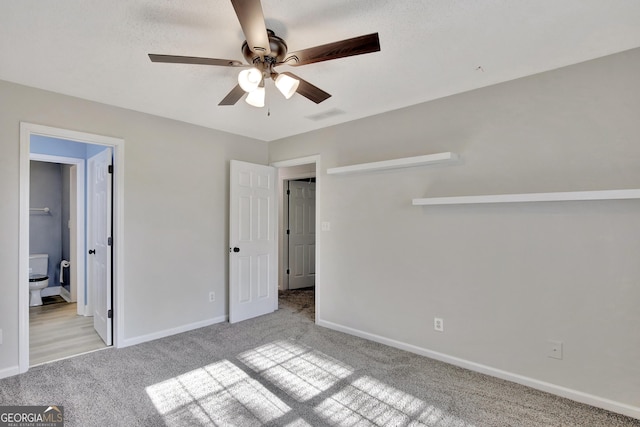 unfurnished bedroom featuring light carpet, ensuite bath, and ceiling fan