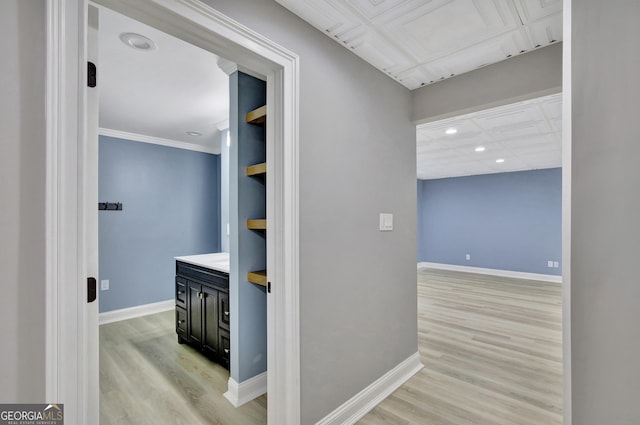 hallway featuring ornamental molding and light wood-type flooring