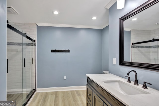 bathroom featuring vanity, crown molding, a shower with door, and hardwood / wood-style flooring