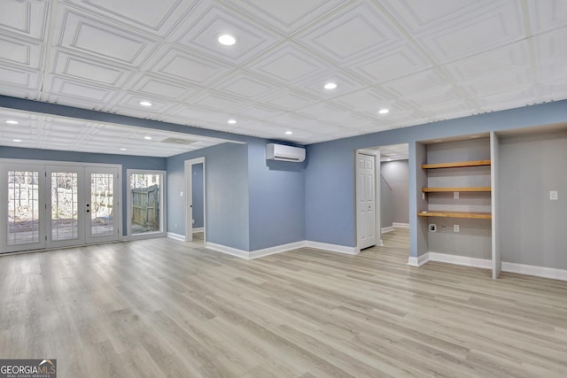 basement featuring french doors, a wall mounted air conditioner, and light hardwood / wood-style flooring