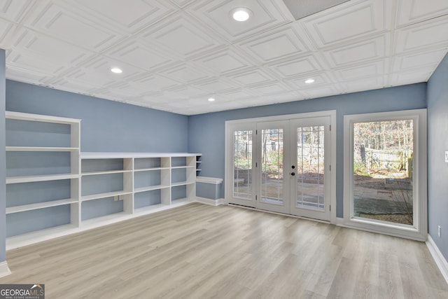 empty room featuring french doors and light wood-type flooring