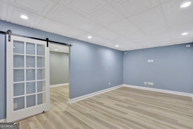 empty room featuring a barn door and light wood-type flooring