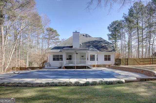 back of property featuring a patio, a pool side deck, and a yard