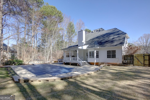 rear view of house featuring a porch and a lawn