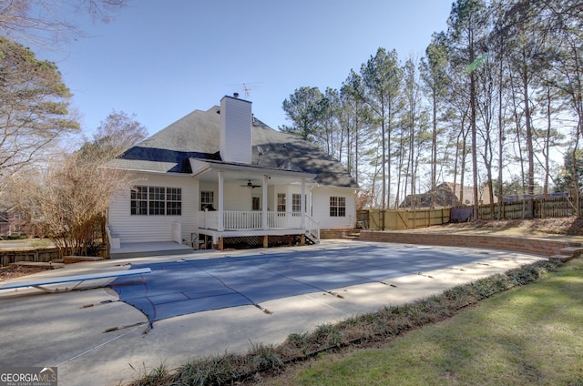 rear view of property featuring a pool side deck, a patio, and ceiling fan