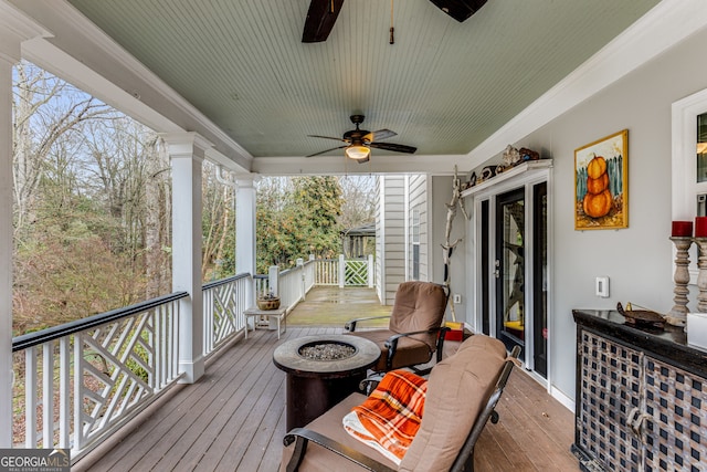 wooden deck featuring ceiling fan and an outdoor fire pit