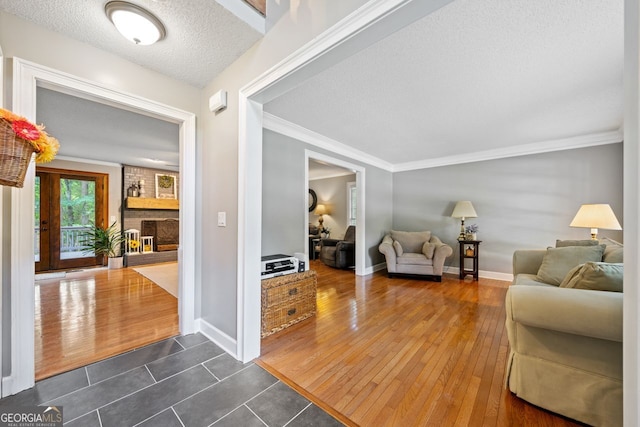 interior space featuring crown molding, a fireplace, dark hardwood / wood-style floors, and a textured ceiling